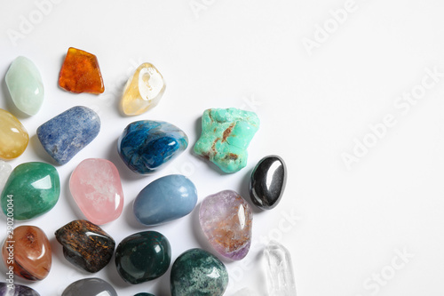 Different beautiful gemstones on white background, top view