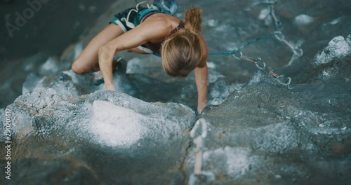 Strong focused woman lead rock climbing with power and style, cinematic slow motion rock climbing moments