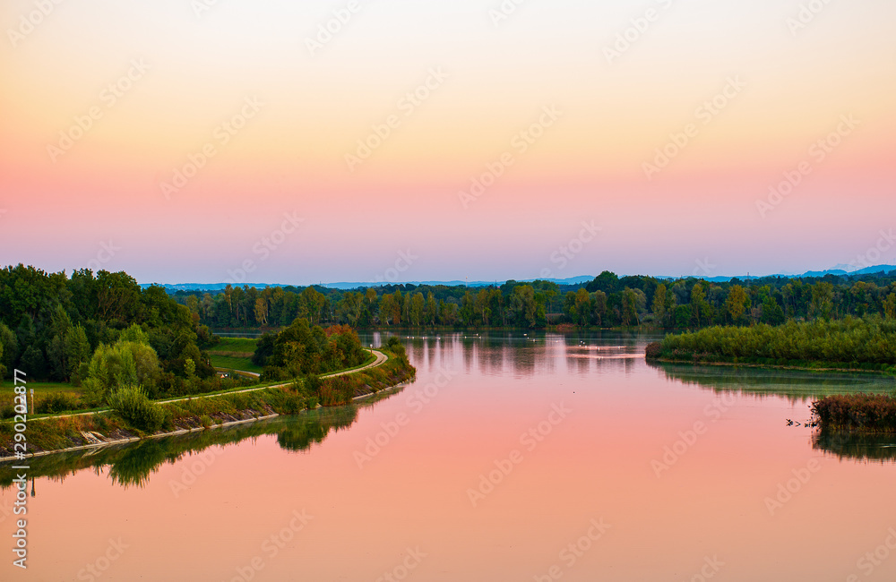 Scenic view of the Lower Inn river at sunset  in early autumn with swans swimming in the background.