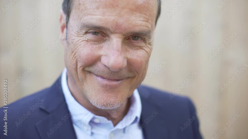 Portrait of handsome mature businessman looking at camera and confidently smiling. Happy attractive man with beard and blue smart jacket smiling. Business and people, lifestyle. Outdoor shot. Portrait of handsome mature businessman looking at camera and confidently smiling. Happy attractive man with beard and blue smart jacket smiling. Business and people, lifestyle. Outdoor shot.