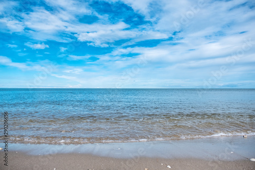 Landscape image of tropical white beach with blue sea and sky background