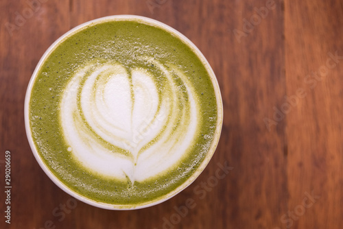 Coffee cup with Green Matcha latte art foam on wood table in coffee shop with copy space.Coffee is one of the most popular beverages.Improve Energy Levels and Burn Fat