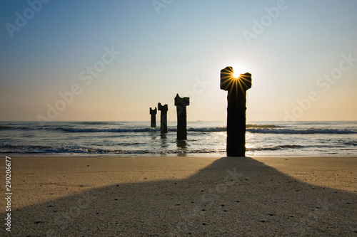 A shining Star burst out of the sun from the pillars of a broken bridge in the sea with copy space, Pondicherry, India photo