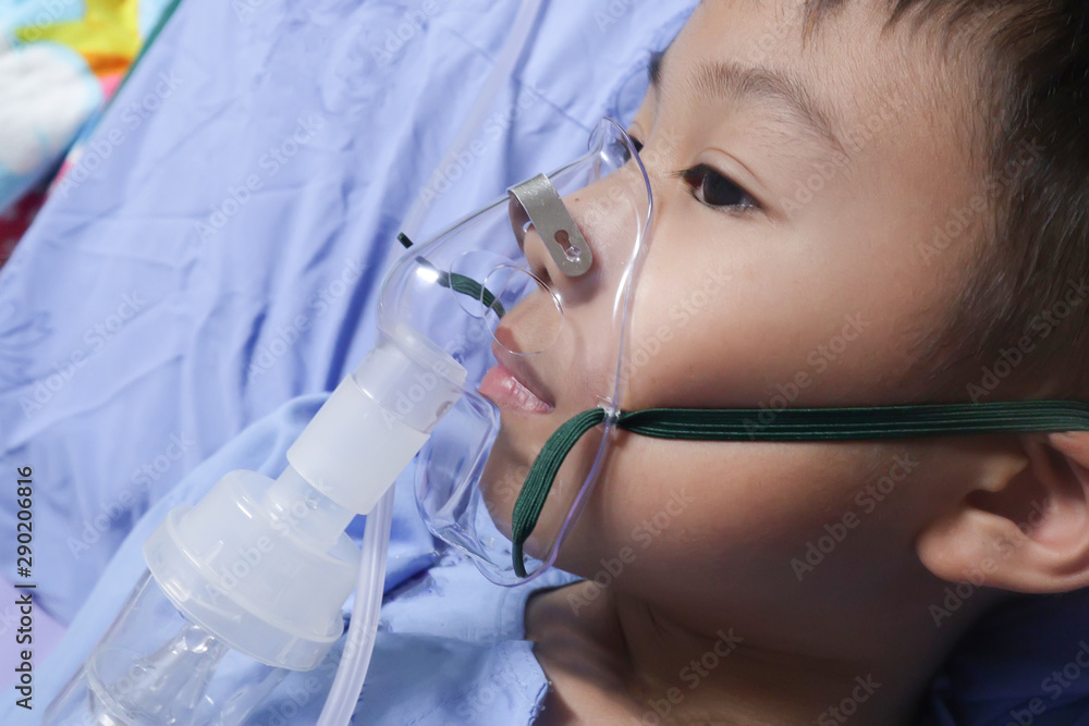 Boy patient with asthma allergy using the asthma inhaler.Inhaler mask for treatment in hospital.Health asthmatic in hospital.healthcare and medical concept Boy patient with asthma allergy using the asthma inhaler.Inhaler mask for treatment in hospital.Health asthmatic in hospital.healthcare and medical concept