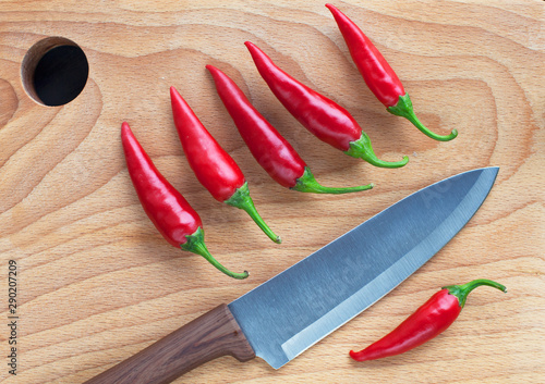 Knife chef red chili pepper on wooden background