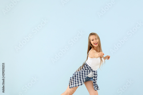 Cool young woman dancing ag...