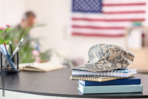 Notebooks and military cap on table in headquarters building