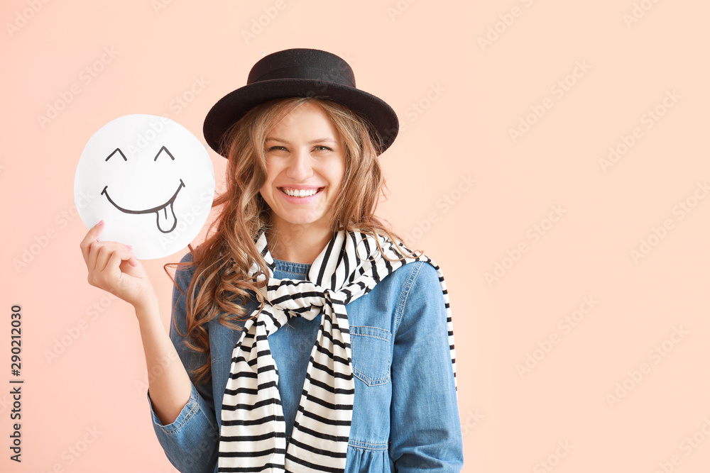 Portrait of happy young woman with emoticon on color background Portrait of happy young woman with emoticon on color background