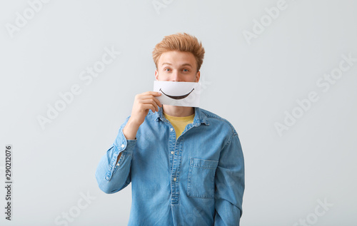 Young man holding paper she...