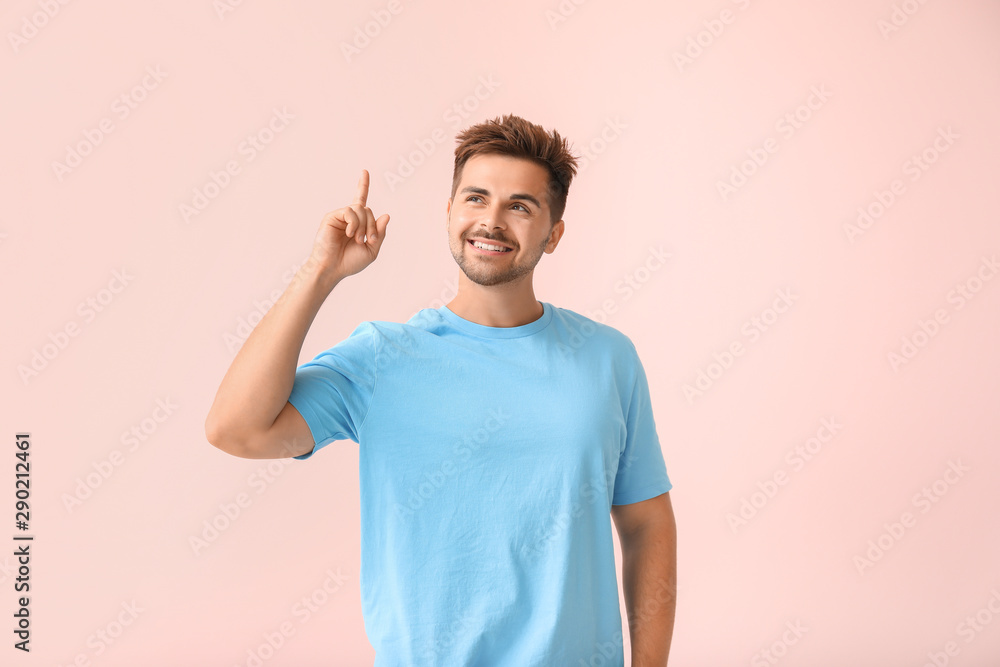 Portrait of happy young man with raised index finger on color background Portrait of happy young man with raised index finger on color background