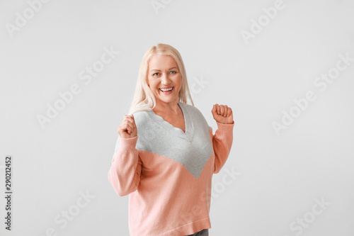 Happy mature woman on grey ...