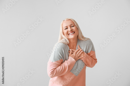 Happy mature woman on grey ...