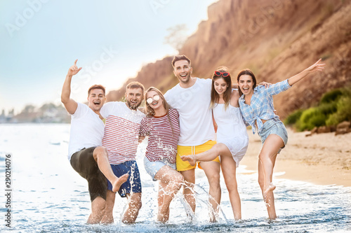 Happy friends on sea beach at resort