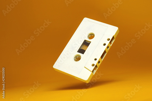 Audio cassette. Vintage white audio cassette tap on colored background. Cassette tape audio on yellow background isolated