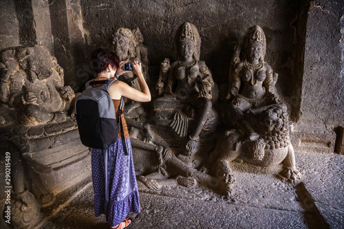 Girl tourist shooting a photo on a smartphone while walking in a Kailash Temple in Ellora. India photo