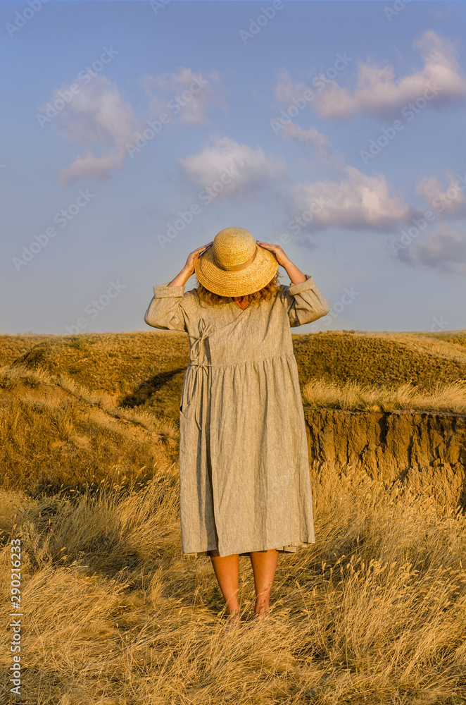 amazing girl in a hat at sunset in the steppe on the sea amazing girl in a hat at sunset in the steppe on the sea