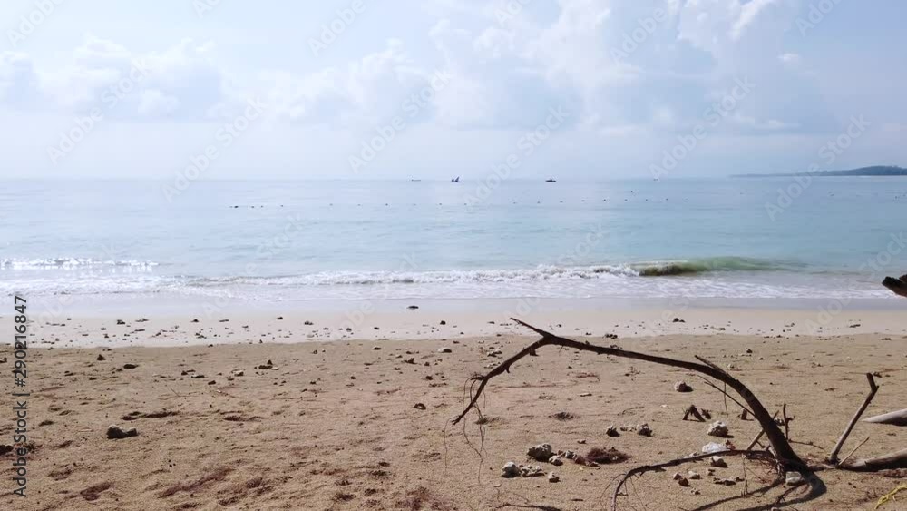Landscape view of the white sea sand beach in summer daytime with some wave and wind blowing in Phuket, Thailand - in slowmotion 4k UHD video Landscape view of the white sea sand beach in summer daytime with some wave and wind blowing in Phuket, Thailand - in slowmotion 4k UHD video