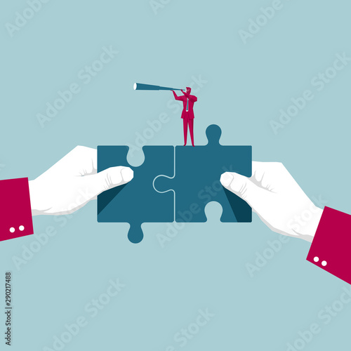 Businessman holding a telescope on a puzzle. Isolated on blue background.