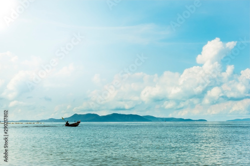 Fishing boats are overwhelmingly in the midst of the sea on a beautiful blue sky.