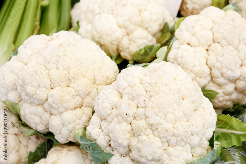 Several heads of cauliflower on display at a local farmers market.
