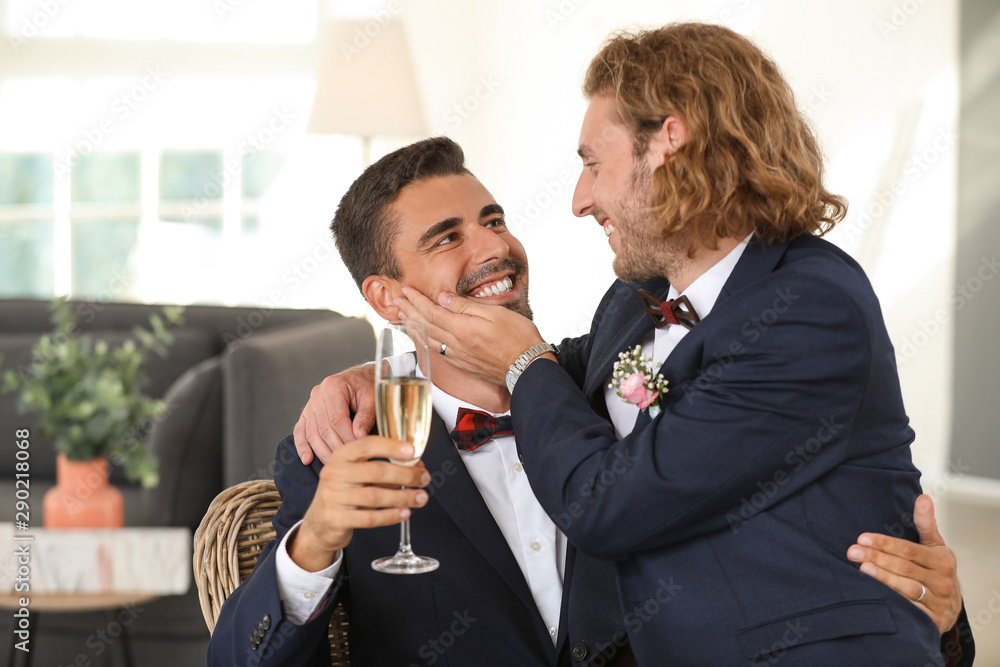 Happy gay couple with champagne on their wedding day at home Happy gay couple with champagne on their wedding day at home