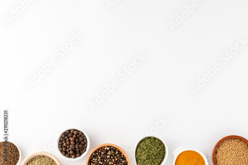 Overhead shot of seasonings in bowls isolated on white background with copyspace