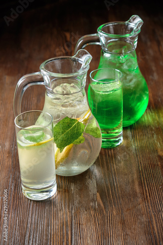 Different soft drinks in transparent jugs on a dark wooden background. menu for catering