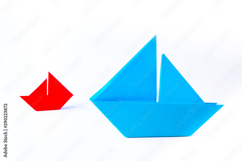 Origami. Two paper boats on a white background. From small grows large. Large and small business. Small things can get big. The pursuit of success, regardless of size. Origami. Two paper boats on a white background. From small grows large. Large and small business. Small things can get big. The pursuit of success, regardless of size.