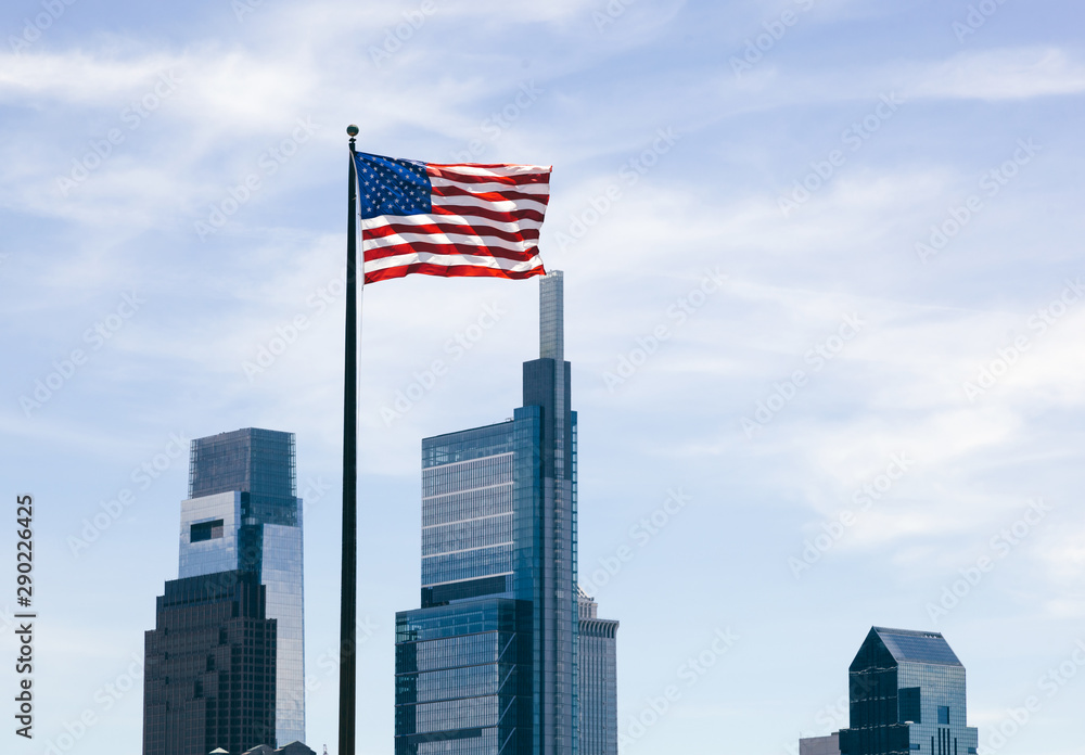 The USA flag overlooking skyscrapers background