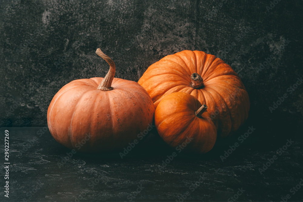 Photo of three orange pumpkins on black background, halloween celebration. Photo of three orange pumpkins on black background, halloween celebration.