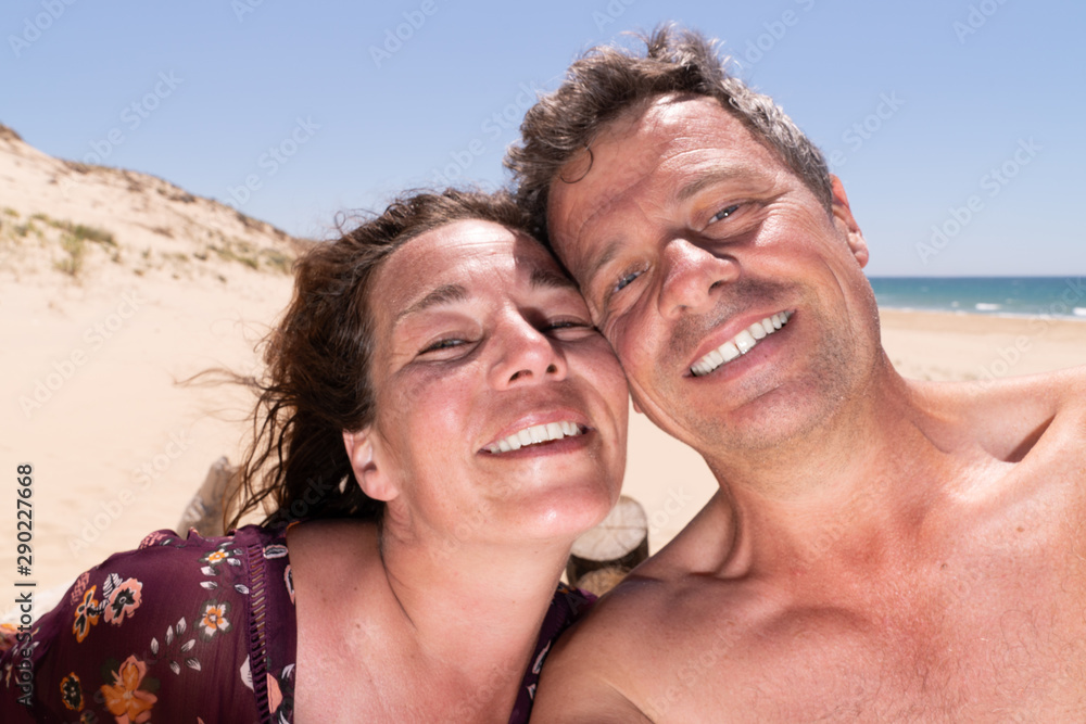 happy couple at the beach taking a selfie happy couple at the beach taking a selfie
