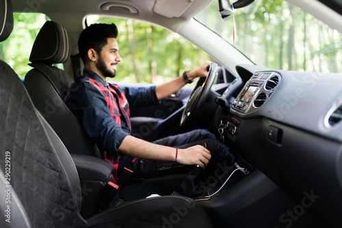 Young indian man in a business suit in the car changes gear © F8 \ Suport Ukraine