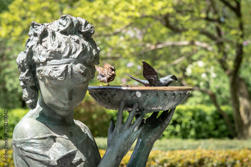 Close up view of the Burnett Fountain in Central Park, with real birds refreshing in the bow. The statue honors children’s book author Frances Eliza Hodgson Burnett