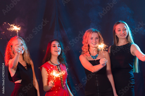 Party, holidays, new year, christmas and nightlife concept - happy young women dancing at night club disco, close-up