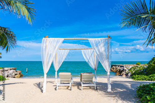 Fototapeta Naklejka Na Ścianę i Meble -  Beautiful umbrella and chair around beach sea ocean with blue sky for travel