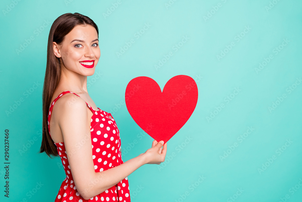 Portrait of lovely youth holding paper card gift for 14-february wearing polka dot dress skirt isolated over teal turquoise green background Portrait of lovely youth holding paper card gift for 14-february wearing polka dot dress skirt isolated over teal turquoise green background