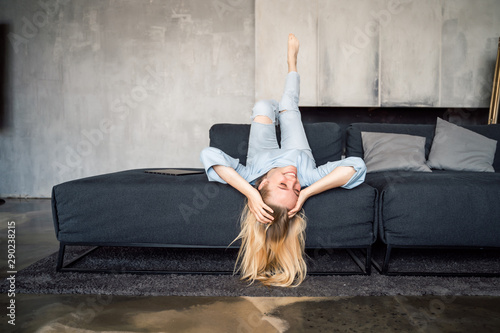 Woman enjoying on a couch with head upside down.