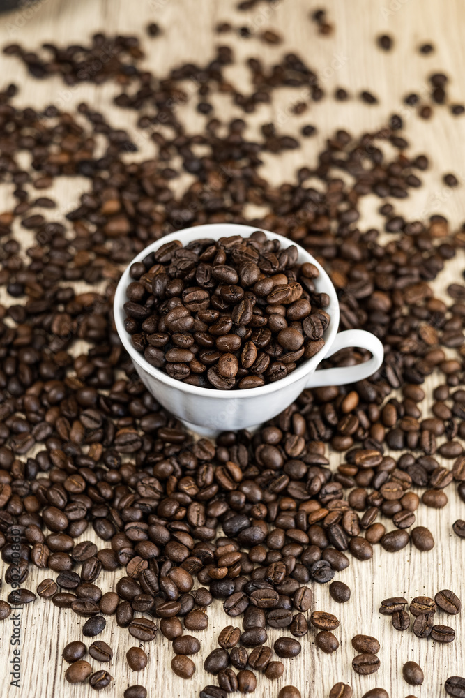 Coffee beans in coffee cup on wood table background. Coffee beans in coffee cup on wood table background.