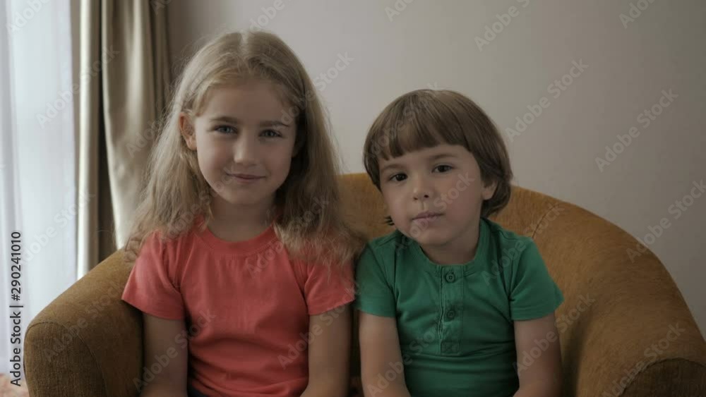 Kids Girl And boy Making Online Video Call Recording Vlog Sitting Sofa , Portrait. Funny Friends Smiling Looking At Camera. Happy Little Children Saying Hello Hi Looking At Camera Talking To Webcam. Kids Girl And boy Making Online Video Call Recording Vlog Sitting Sofa , Portrait. Funny Friends Smiling Looking At Camera. Happy Little Children Saying Hello Hi Looking At Camera Talking To Webcam.
