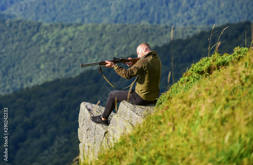 Hunting masculine hobby concept. Regulation of hunting. Focused on target. Hunter hold rifle. Hunter spend leisure hunting. Man brutal gamekeeper nature landscape background. Hunting in mountains