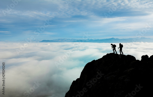peaks of foggy mountains, professional climber team and successful climb