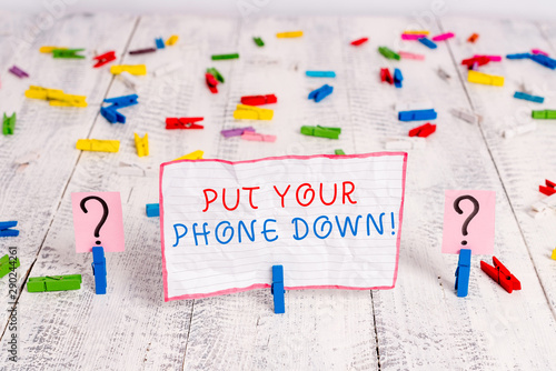 Handwriting text writing Put Your Phone Down. Conceptual photo end telephone connection saying goodbye caller Scribbled and crumbling sheet with paper clips placed on the wooden table