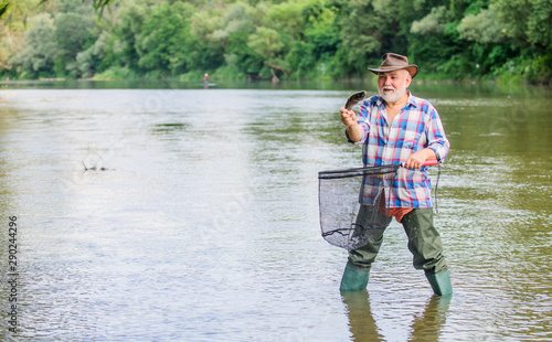 Fisherman fishing equipment. Fisherman alone stand in river water. Pensioner leisure. Man senior bearded fisherman. Hobby sport activity. Fish farming pisciculture raising fish commercially