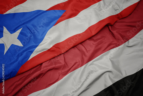 waving colorful flag of yemen and national flag of puerto rico.