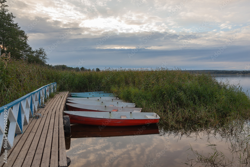 Φωτογραφία Beautiful evening scenery with colorful boats moored to the pier on a lake in Valdaysky District, Russia