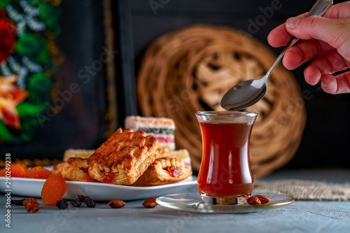 Photography Turkish tea in an authentic glass with sweets, dried fruits and nuts for a teati