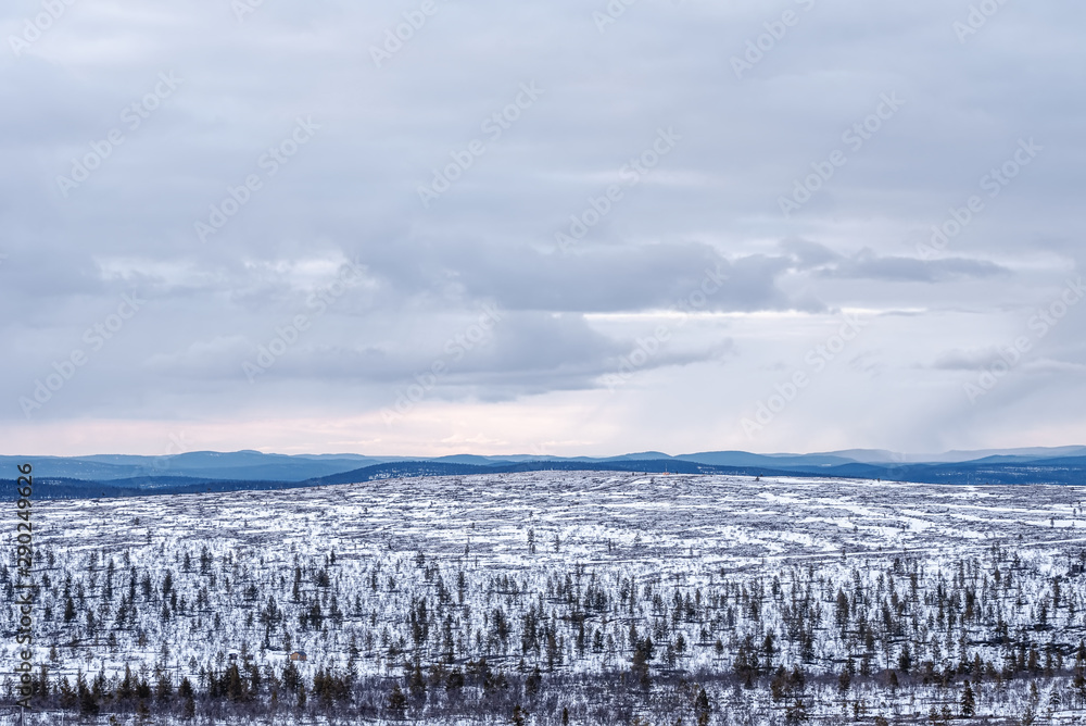 View of the snowy hills in severe nature of northern Finland View of the snowy hills in severe nature of northern Finland