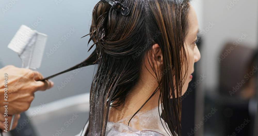 Naklejka premium Woman having hair treatment in hair salon