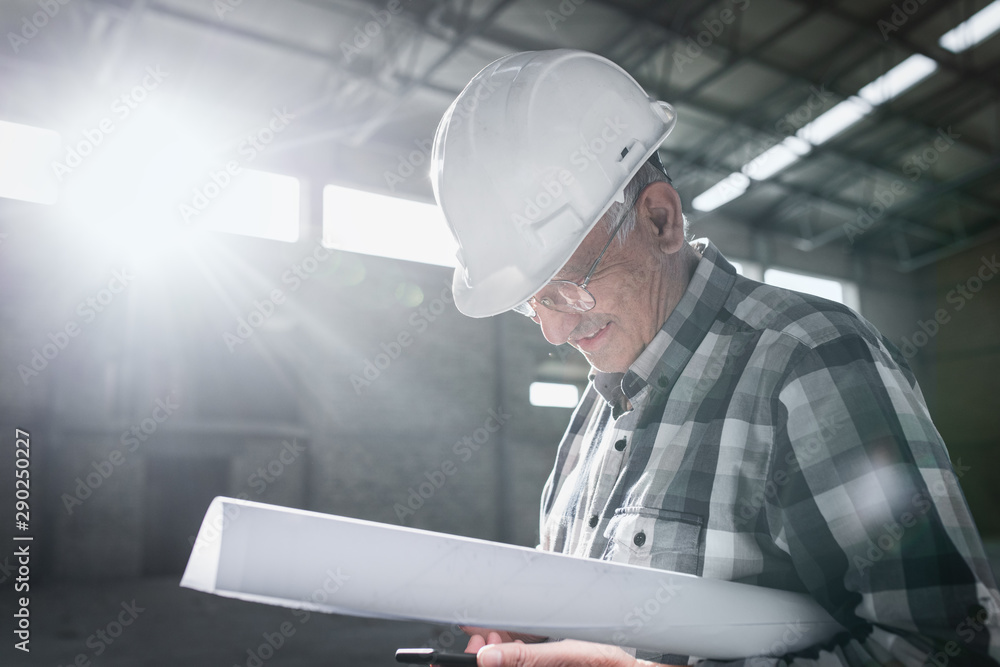 Senior construction worker with blueprint controlling building site. Senior construction worker with blueprint controlling building site.