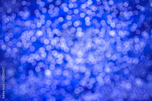 Abstract beautiful blurred brightness purple colored bokeh from electric blue ornamental lights flickering in the park. Background for celebrate party, merry Xmas, happy new year concept.